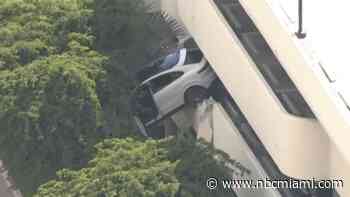 WATCH: Porsche SUV left dangling from parking garage in Coral Gables