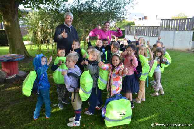 Burgemeester Tuybens deelt fluo rugzakhoezen uit