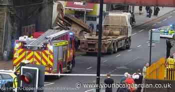 Busy Putney road closed after flatbed lorry crashes into bridge near station