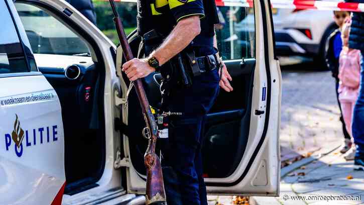 Oude man loopt over straat met groot wapen, getuige belt politie