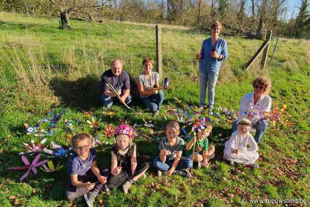 Kunstenaars en kinderen maken samen kleurrijke windmolentjes