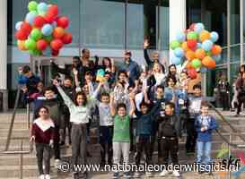 Kinderen Zomerschool geven boek met verhalen aan jarig Amsterdam
