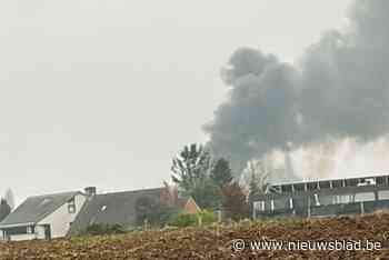 Uitslaande brand met enorme rookpluim in loods met tractoren en banden: “Geen gewonden, brand onder controle”