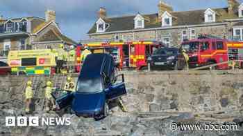 Driver rescued after car falls on to beach