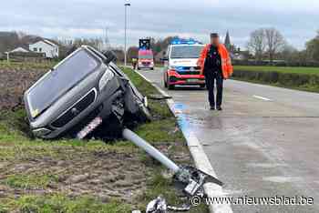 Bestelwagen knalt tegen verlichtingspaal en belandt in gracht