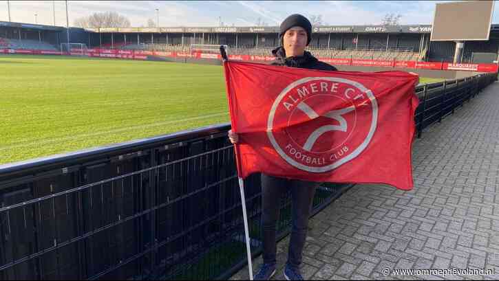 Almere - Ruben (16) steunt Almere City door met een vlag te rennen