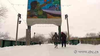 Mural and concrete counterweight being removed from rail bridge at The Forks