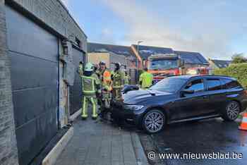 Auto glijdt uit in bocht en knalt tegen garageboxen: brandweer komt stutten