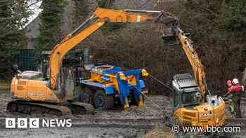 Watch: Stranded digger rescued from drained pond