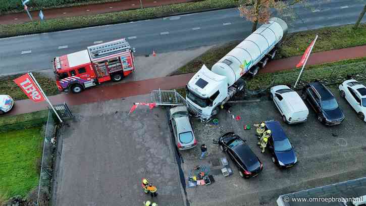 Vrachtwagen rijdt door hek en ramt auto's op parkeerplaats
