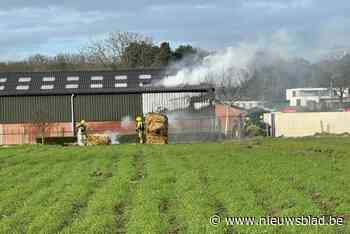 Brandweer dooft brandend hooi in schuur naast boerderij