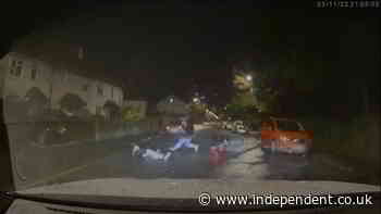 The moment a police car knocks two men off motorbike