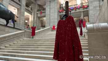 Candles, photos, hearts and red dresses pay tribute to MMIWG2s+ at Manitoba legislative building