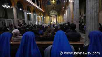 Pope Francis sits upright in an armchair as Argentines in Rome pray for his recovery