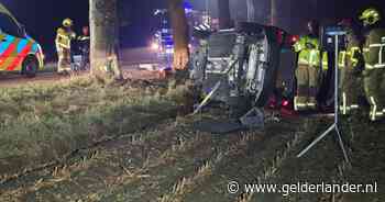 Automobilist rijdt na stuurcorrectie tegen boom en komt op zijkant tot stilstand in veld