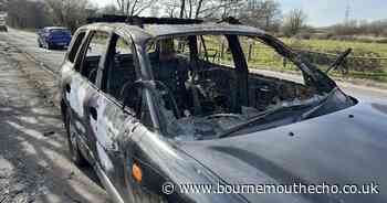 Abandoned car set on fire along busy road