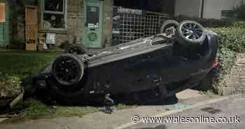 Boy arrested after car found upside-down in garden