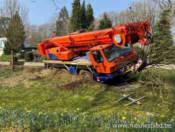 Mobiele kraan gaat van de weg en belandt op hellende berm in Lummen