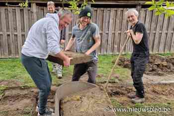 Leerkrachten en directeur wippen tegels weg om haag te planten