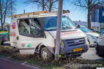 Bedrijfsbus ramt lantaarpaal op het Damsterdiep