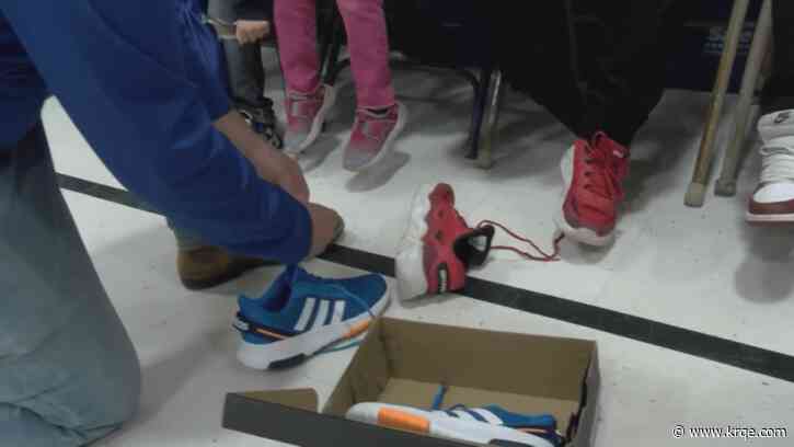 KRQE Cares Shoes for Kids holding April phone bank