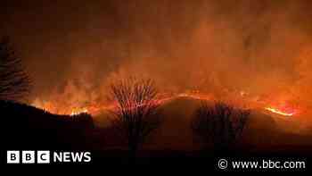 Evacuations as wildfire spreads north through forest