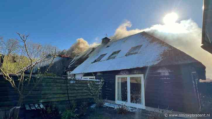 Grote brand in huis met rieten dak, rook trekt over het spoor