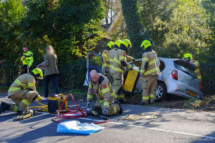 Auto belandt in greppel bij botsing op kruising, één persoon naar ziekenhuis