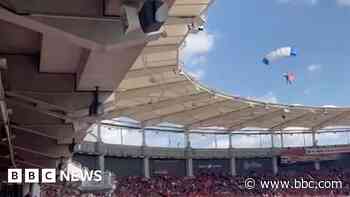 Moment parachutist left dangling on stadium roof
