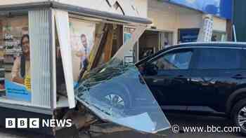 Car crashes into shop and damages front window
