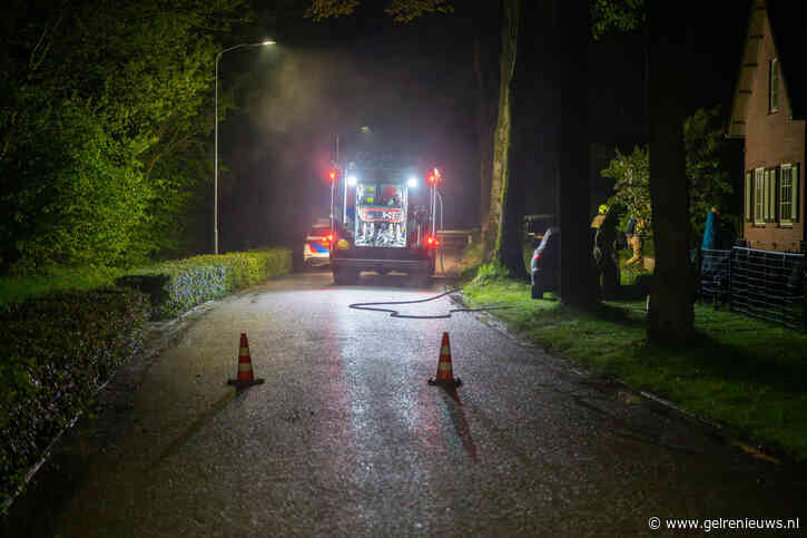 Brand in dak van schuur, brandweer breekt dak open voor blussing