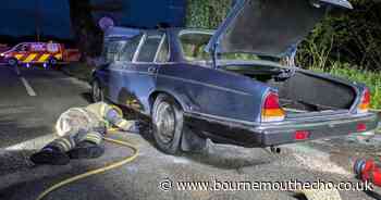 Fire put out underneath classic Jaguar
