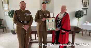 Town mayor and military officer swap plaques after special honour