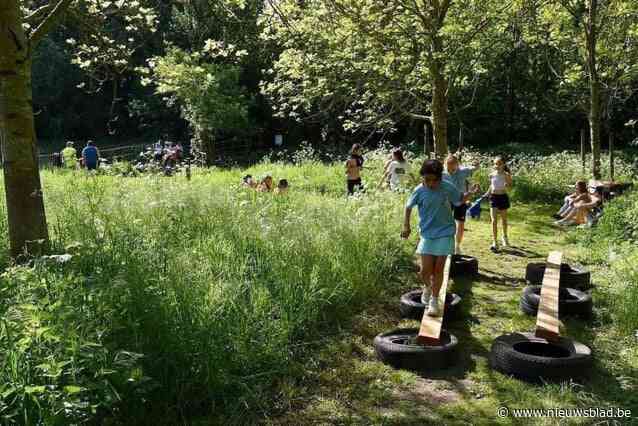 Schoolkinderen overwinnen obstakels op hindernissenrun
