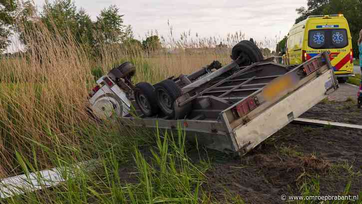 Auto met aanhanger belandt op zijn kant in de sloot