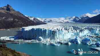Tourists watch as a massive chunk of ice breaks off Argentinian glacier