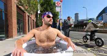 Bemused commuters spot man taking an ice bath outside a bus stop as balmy weather continues
