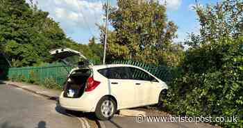 Car mounts pavement and crashes into fence over railway line