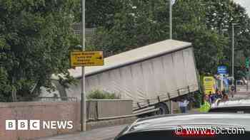 Lorry left hanging off side of bridge after crash