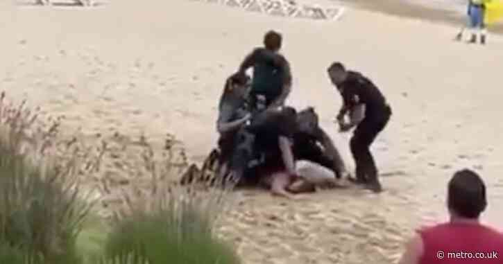 Tourist beaten by police after trying to shadowbox them naked