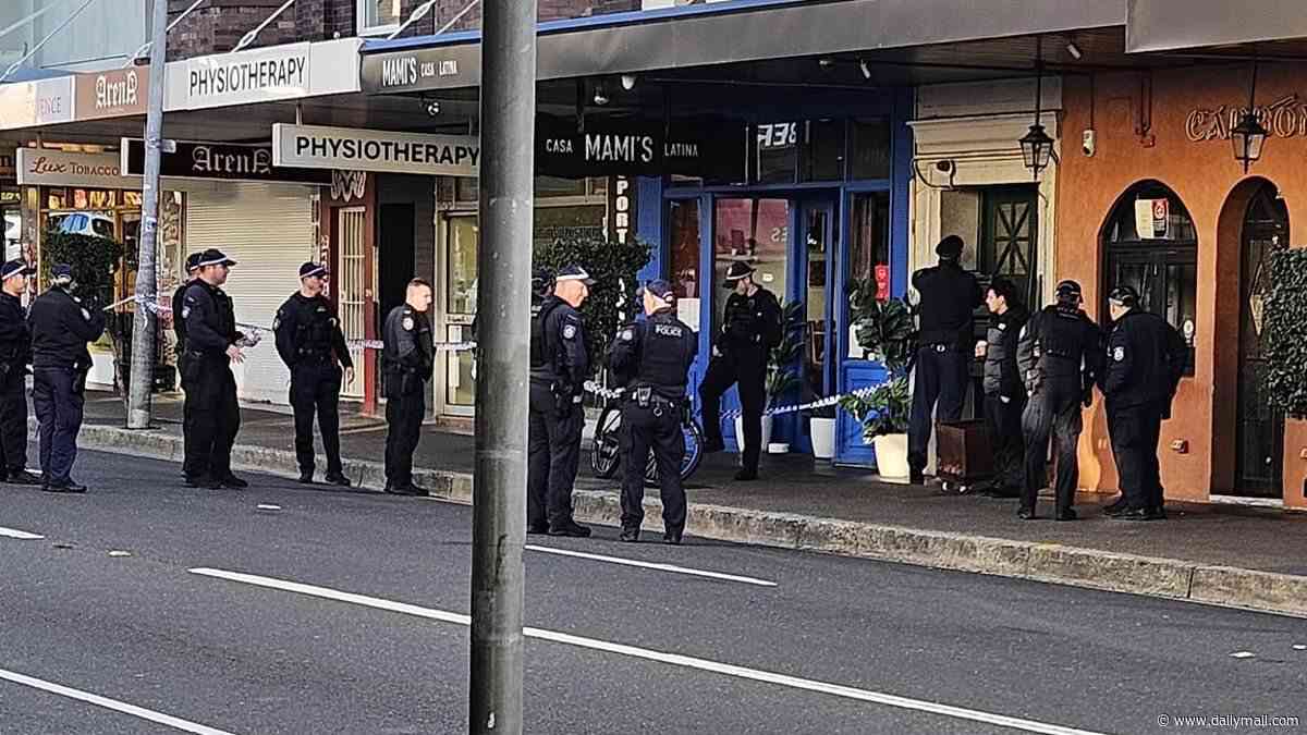 Police swarm to Bondi: Road is closed and man is rushed to hospital as a dozen officers race to scene