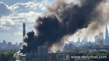 Around 100 firefighters battle huge blaze at recycling centre as thick plumes of smoke billow across London skyline