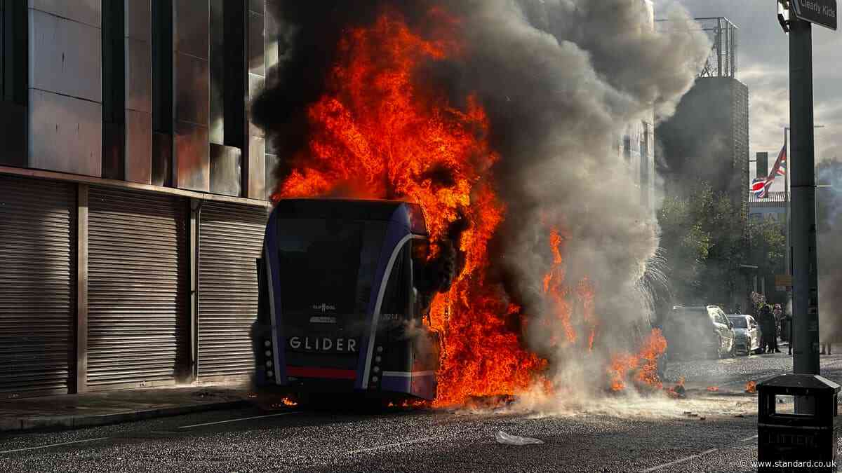 Belfast protesters set bus on fire and throw objects at police as disorder erupts after knife attack