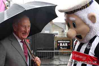 Charles braves downpour to meet football club’s mascot
