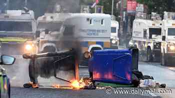Makeshift barricade is set on fire near homes in Belfast on third night of riots over Sudanese migrant 'knife attack'