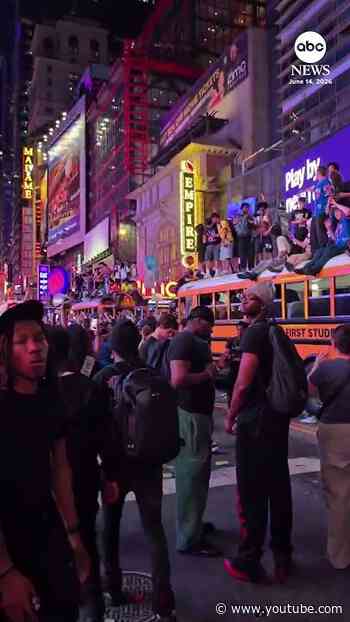 Fans scale buses in Times Square after Knicks win NBA title