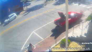 Woman almost flattened by speeding car after it mounts sidewalk