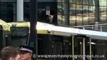 Emergency services descend as man climbs onto roof of Manchester tram