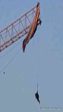 Paraglider left dangling 60 metres in the air after getting caught on tower crane