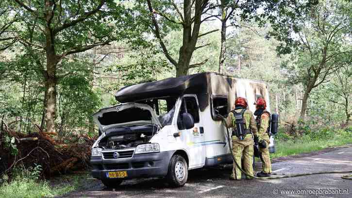Camper in vlammen op tijdens picknick van gezin in bos